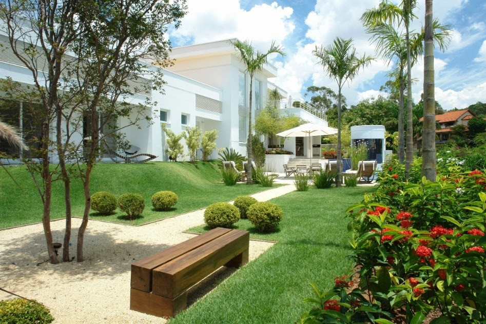 Jardim contemporâneo com piso e gramado