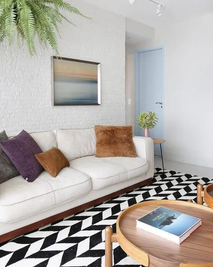 Sala com parede branca e tapete preto e branco